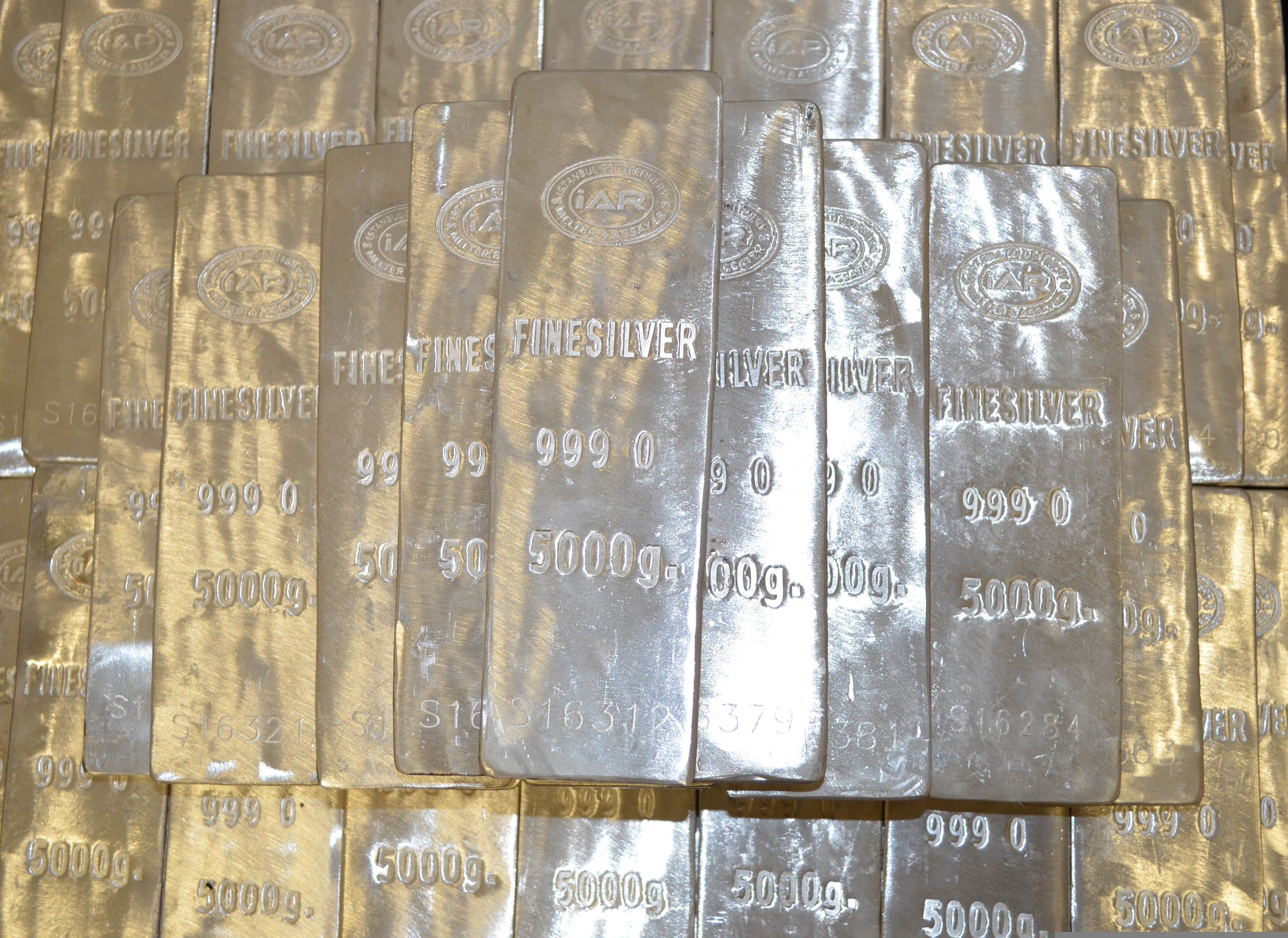 Stack of poured silver bars with soft cool reflections and crystalline surface texture